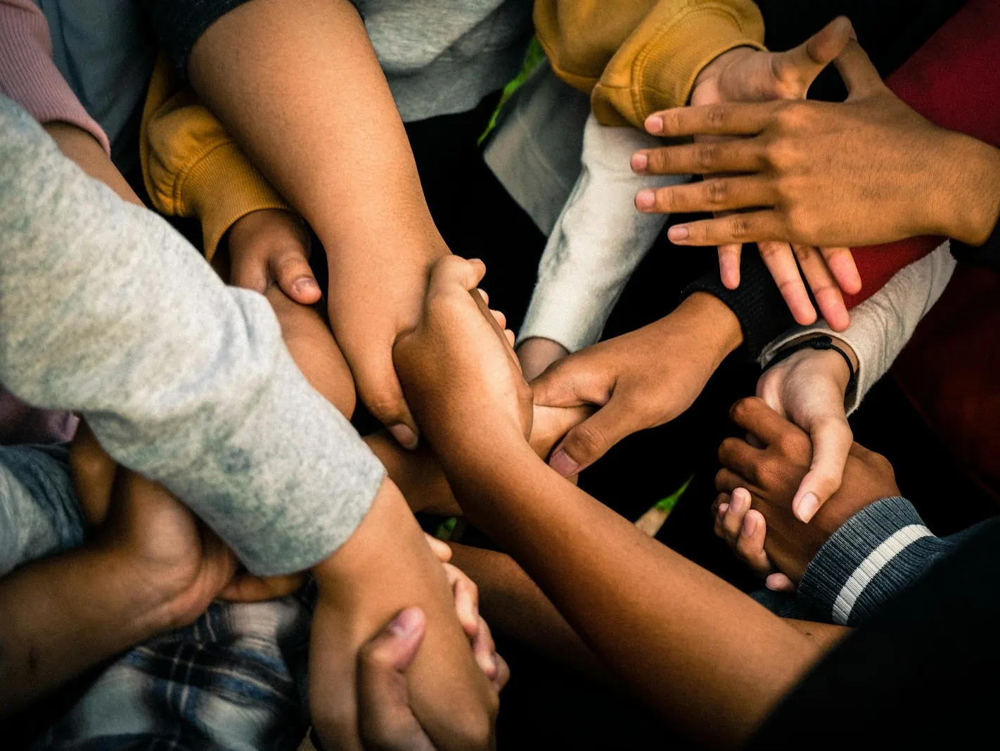 A group of people joining hands in solidarity and community support